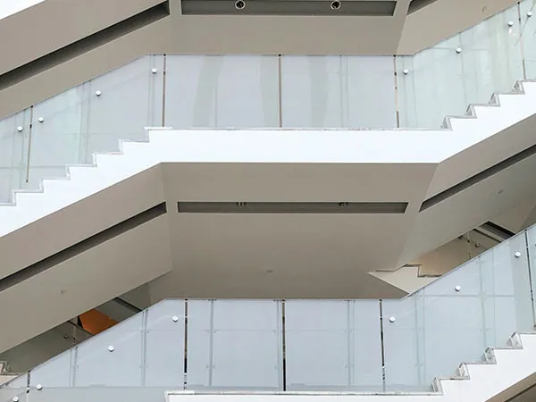 Interior staircase flights edged with frameless glass balustrades on round point anchors