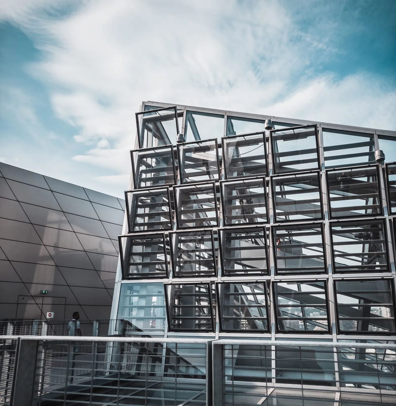 Steel-framed building exterior part-clad in dark panels with glazing between the frames