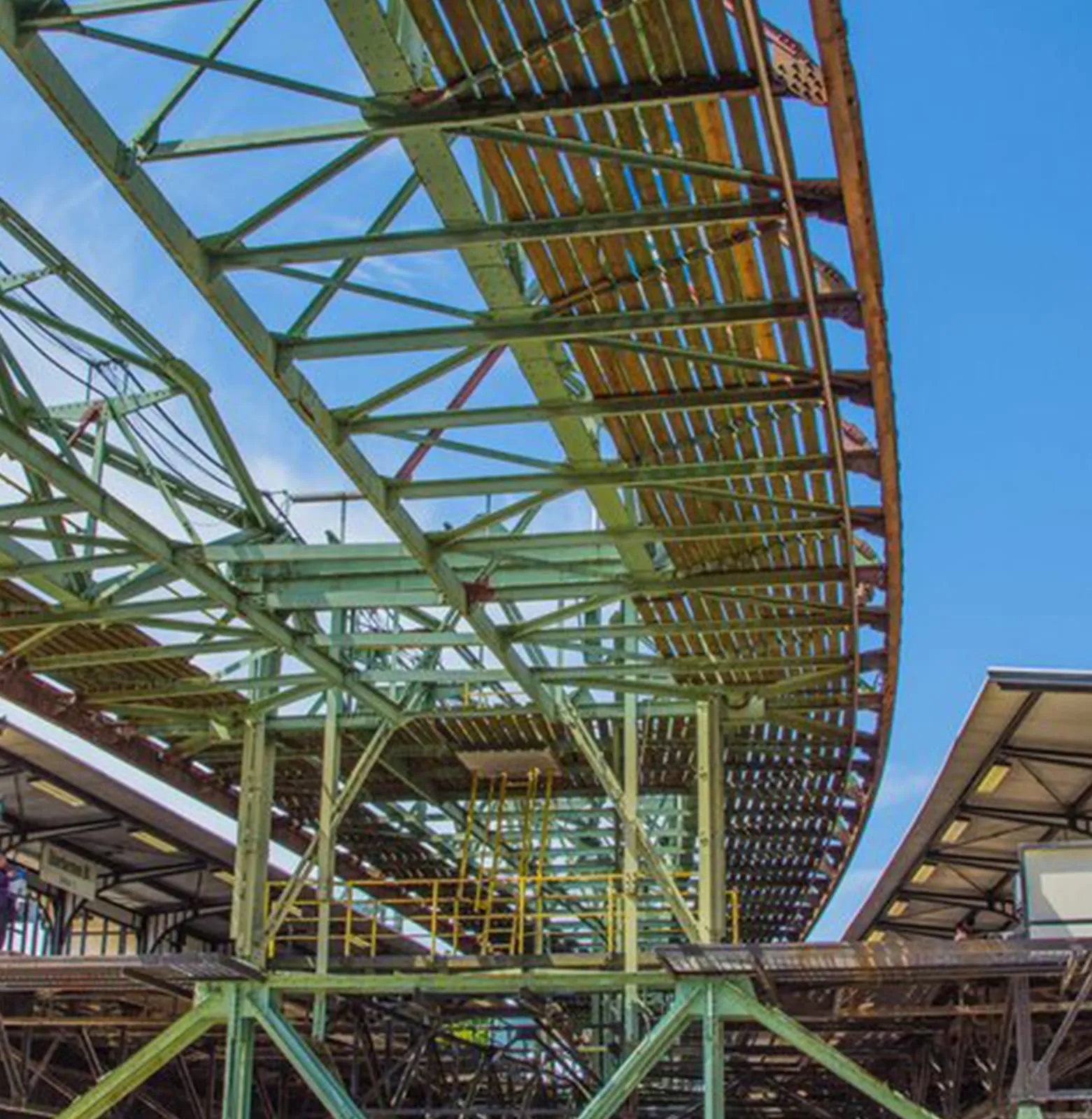 Painted steel roof structure inside a building under construction, members meeting at a ridge